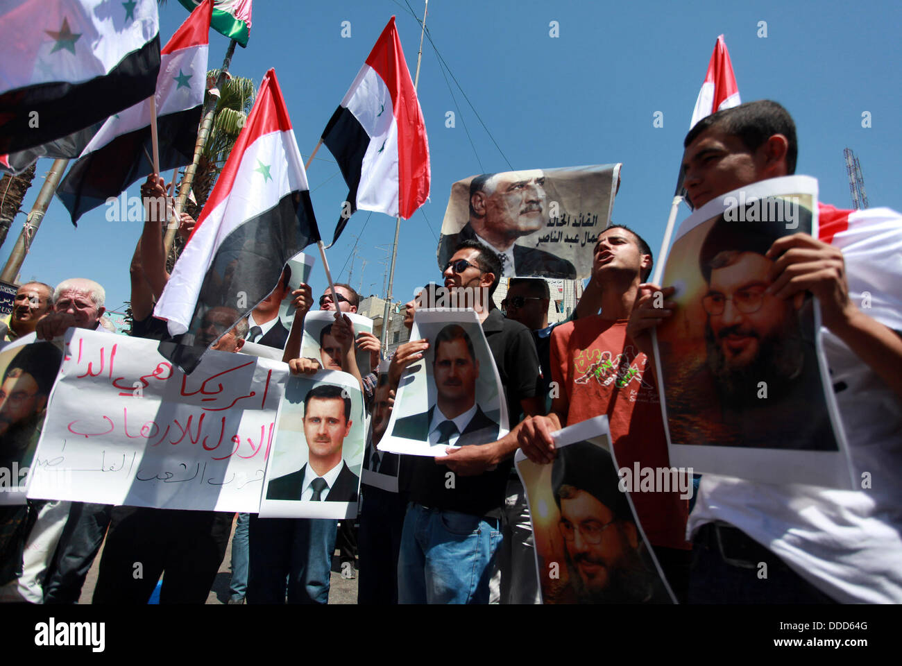 Ramallah, West Bank, Territorio palestinese. 31 Agosto, 2013. I dimostranti palestinesi tenere un flag e poster della Siria il Presidente Bashar al-Assad durante una dimostrazione contro possibili scioperi sul governo siriano, in Cisgiordania città di Ramallah Agosto 31, 2013 Credit: Issam Rimawi APA/images/ZUMAPRESS.com/Alamy Live News Foto Stock