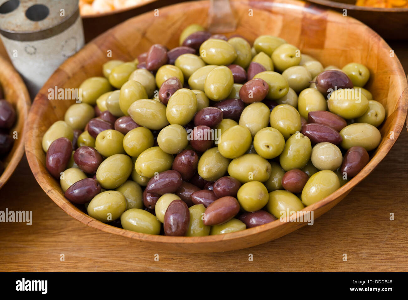 Verde e nero le olive in un recipiente di bambù Foto Stock