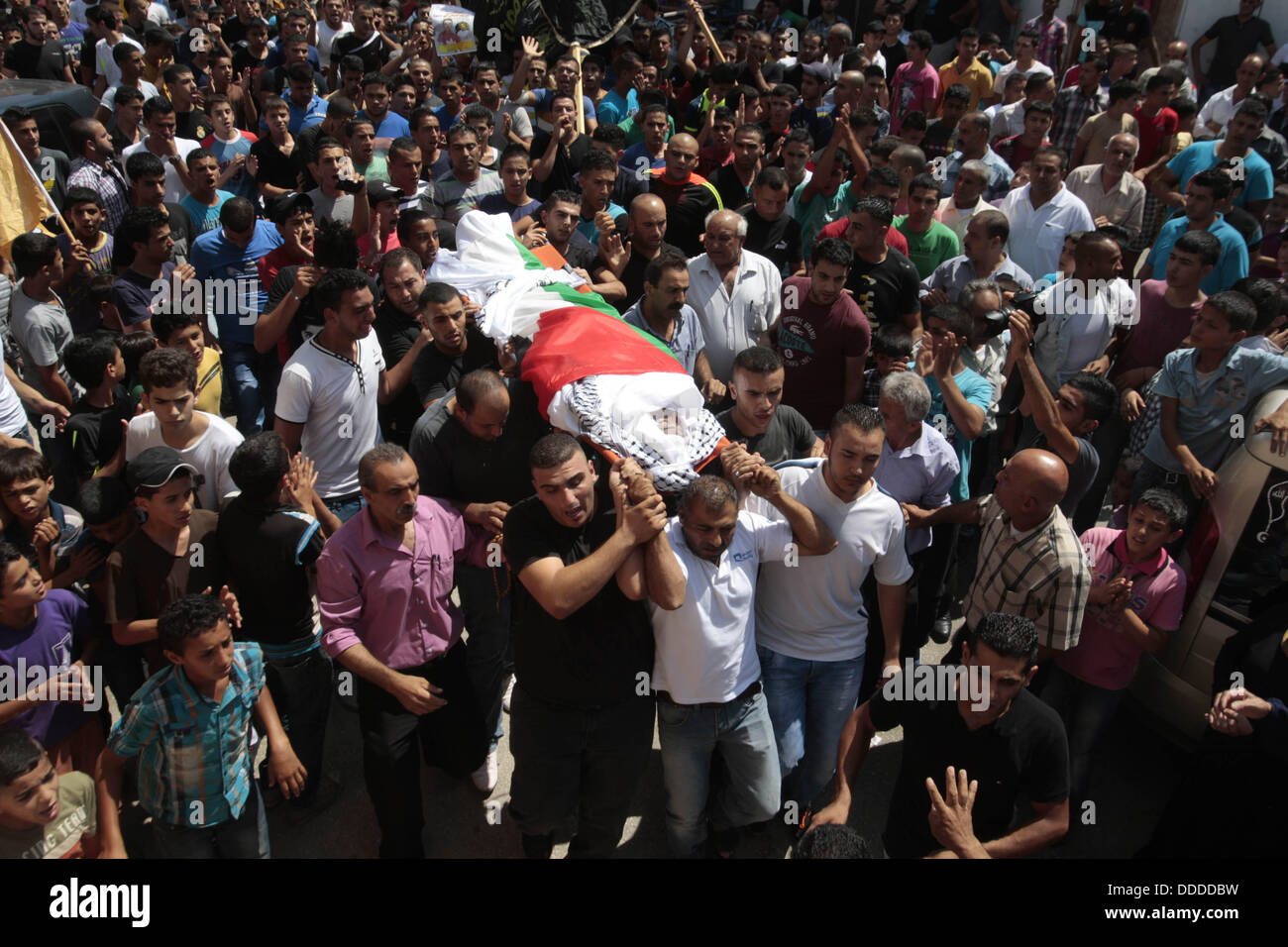 Jenin, West Bank. 31 Agosto, 2013. Palestinesi portano il corpo di Kareem Abu Sbeih durante il suo funerale nel campo profughi di Jenin sabato. Abu Sbeih morì dalle sue ferite sabato dopo essere scattato più di una settimana fa quando i soldati israeliani sparato a una folla violenta come giunsero sotto attacco nel corso di un raid a Jenin per arrestare un sospetto militante. Un altro uomo è stato ucciso durante il raid. Credito: Nedal Eshtayah APA/images/ZUMAPRESS.com/Alamy Live News Foto Stock