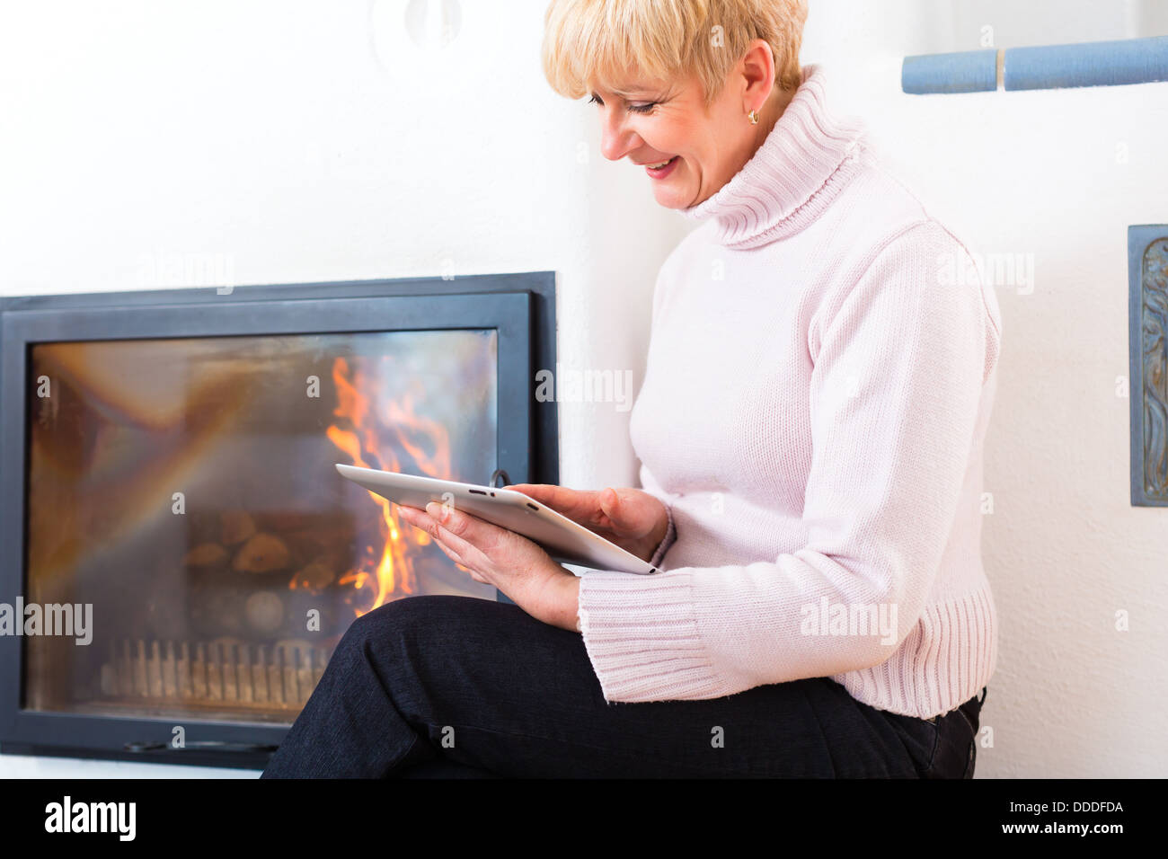 Qualità della vita - la donna più anziana o pensionato femmina seduti a casa davanti al forno Foto Stock