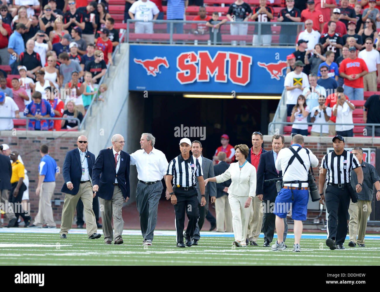 Il 30 agosto 2013 - University Park, TX, Stati Uniti d'America - 30 agosto 2013: ex presidente degli Stati Uniti George Bush Jr e ex First Lady Laure Bush a piedi per il centro del campo flipping il coin toss prima che il gioco tra il Texas Tech Red Raiders e il Southern Methodist Mustangs a Gerald Ford J. Stadium in University Park, Texas Tech vince contro SMU, 41-23. Foto Stock