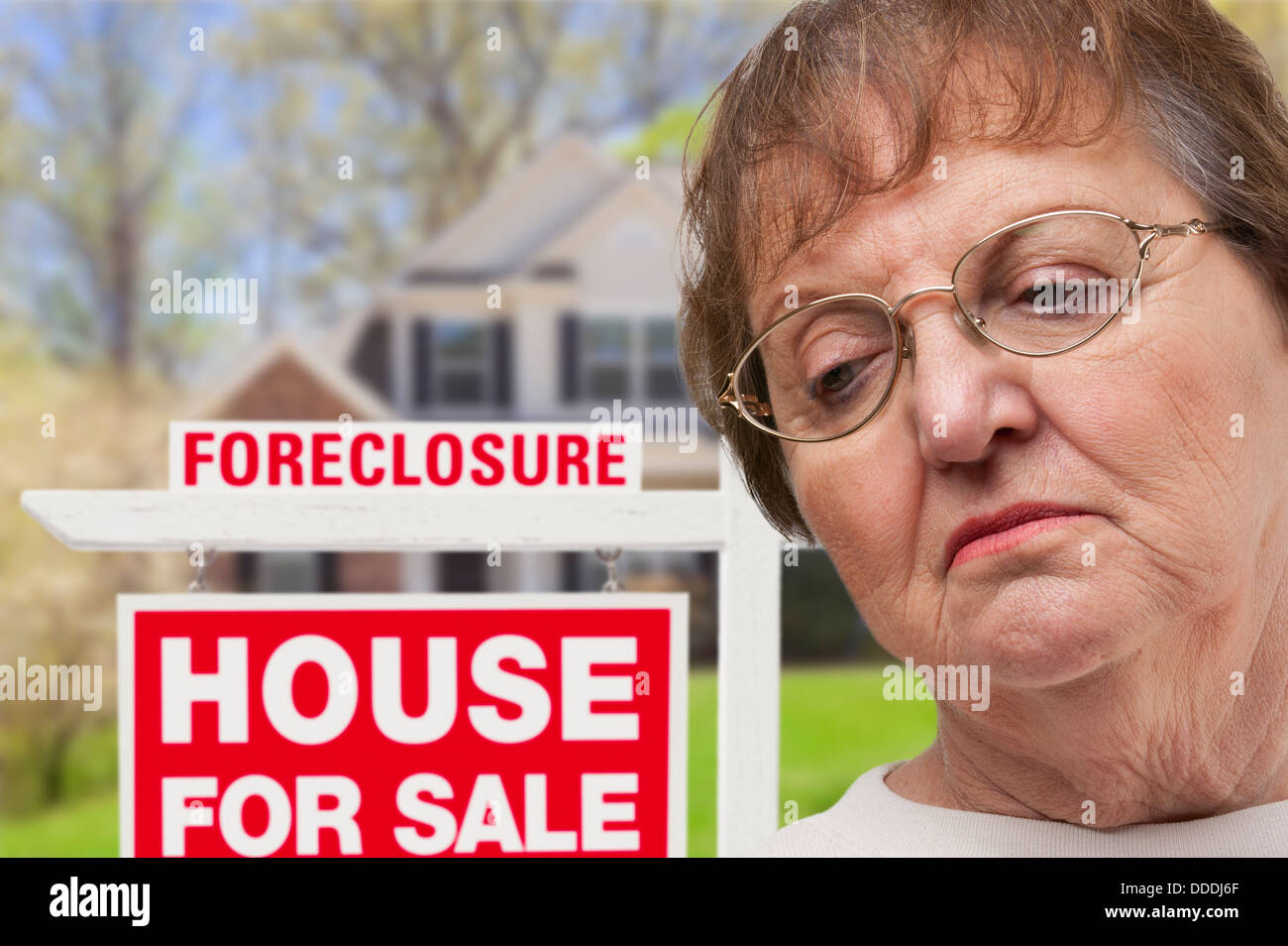 Premuto Senior Donna di fronte di preclusione del mercato immobiliare di segno e la casa. Foto Stock