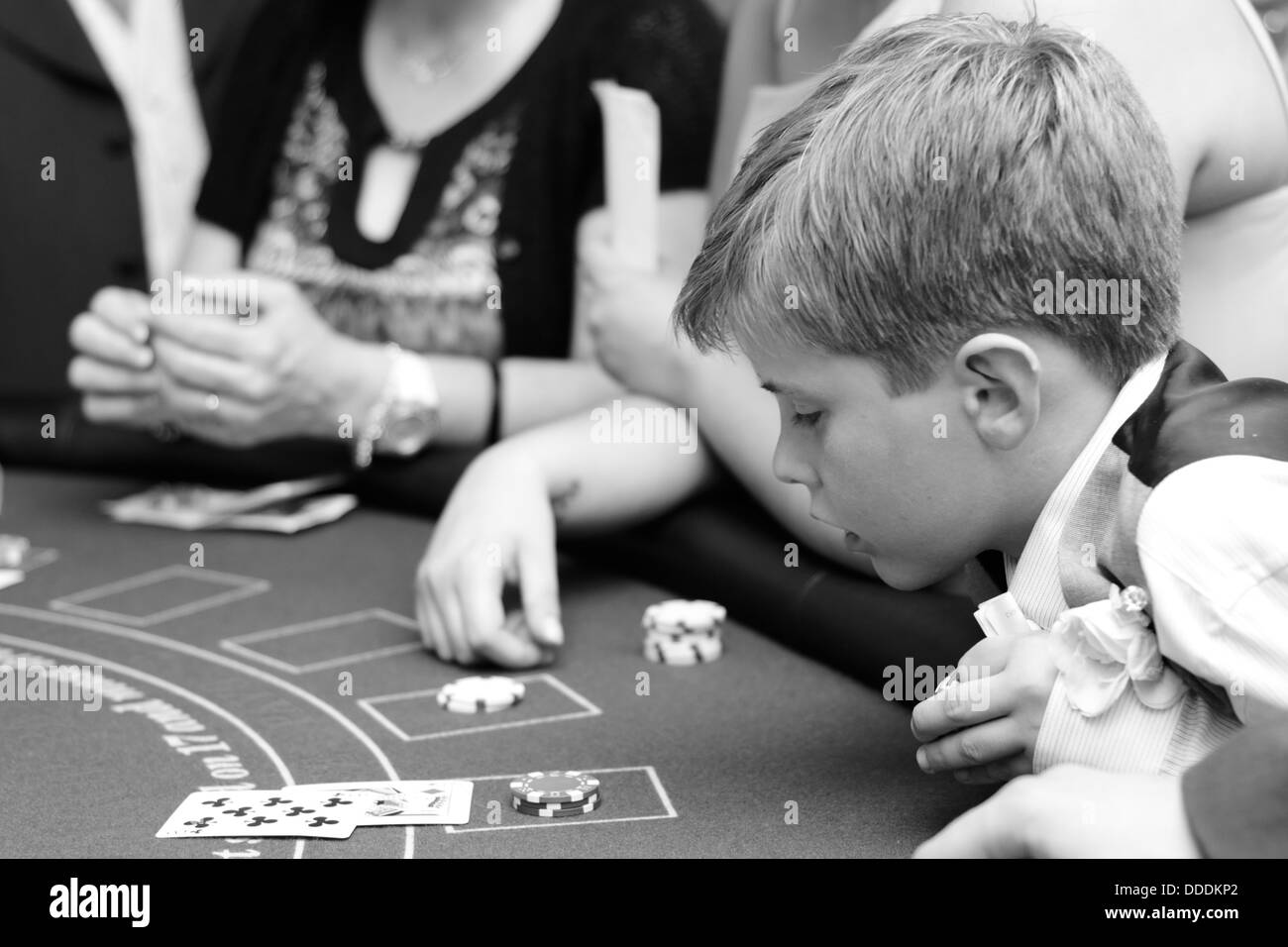 Ragazzo appoggiato su un tavolo di Blackjack circa il gioco d'azzardo Foto Stock