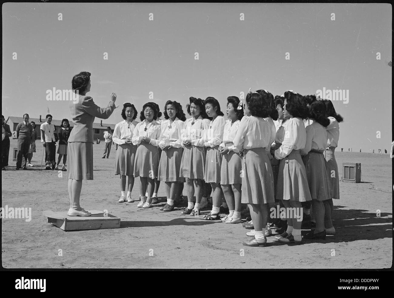 Il Glee Club delle ragazze delle scuole superiori del Granada Relocation Center, Amache, Colorado, si esibiva nel campo durante la seconda guerra mondiale. Il Glee Club era un'importante attività sociale e culturale per gli internati. Foto Stock