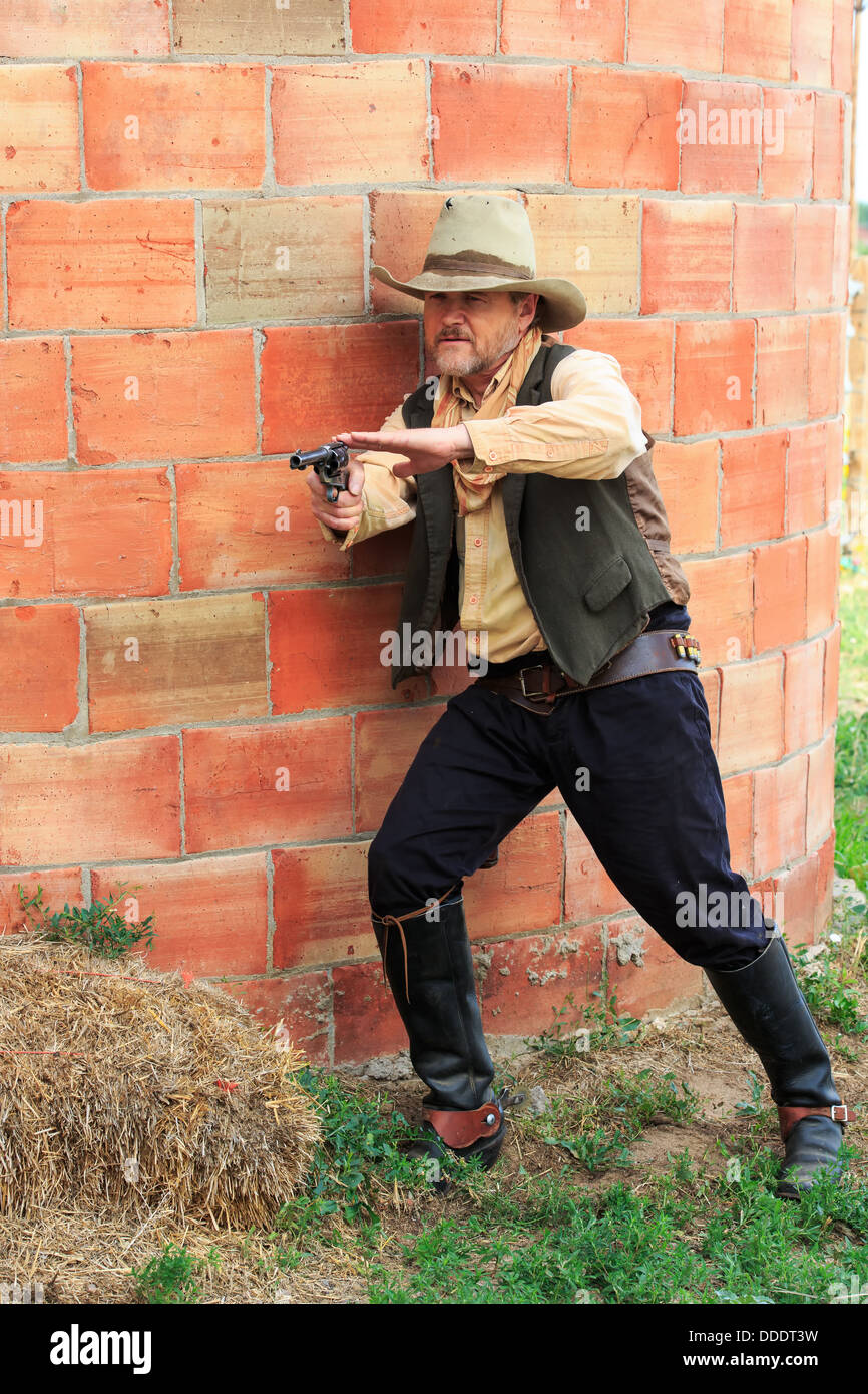 Un gunfighter prende il coperchio durante le riprese la sua arma Foto Stock
