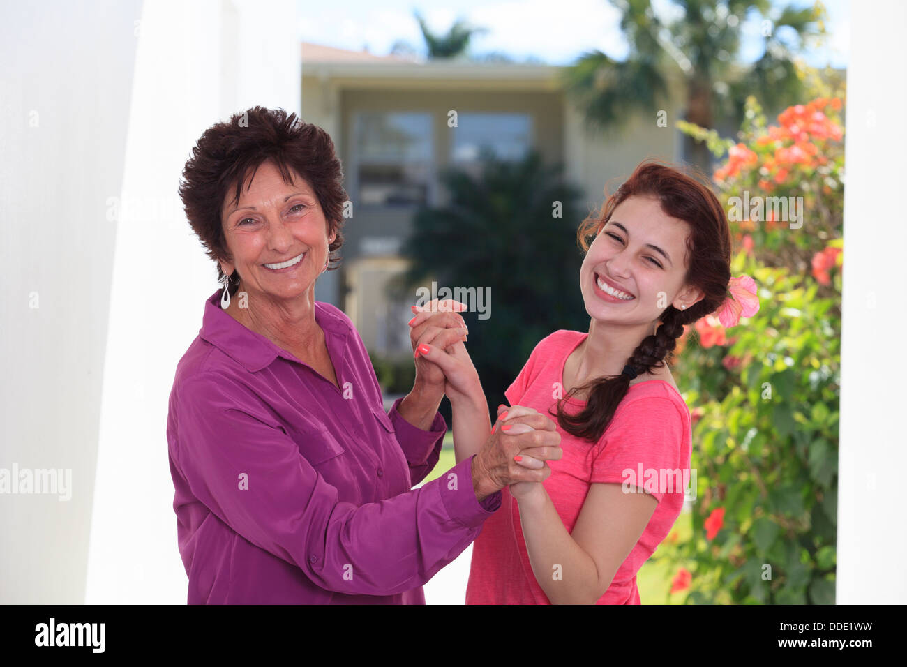 Senior donna sorridente e suo nipote tenendo le mani di ogni altro Foto Stock