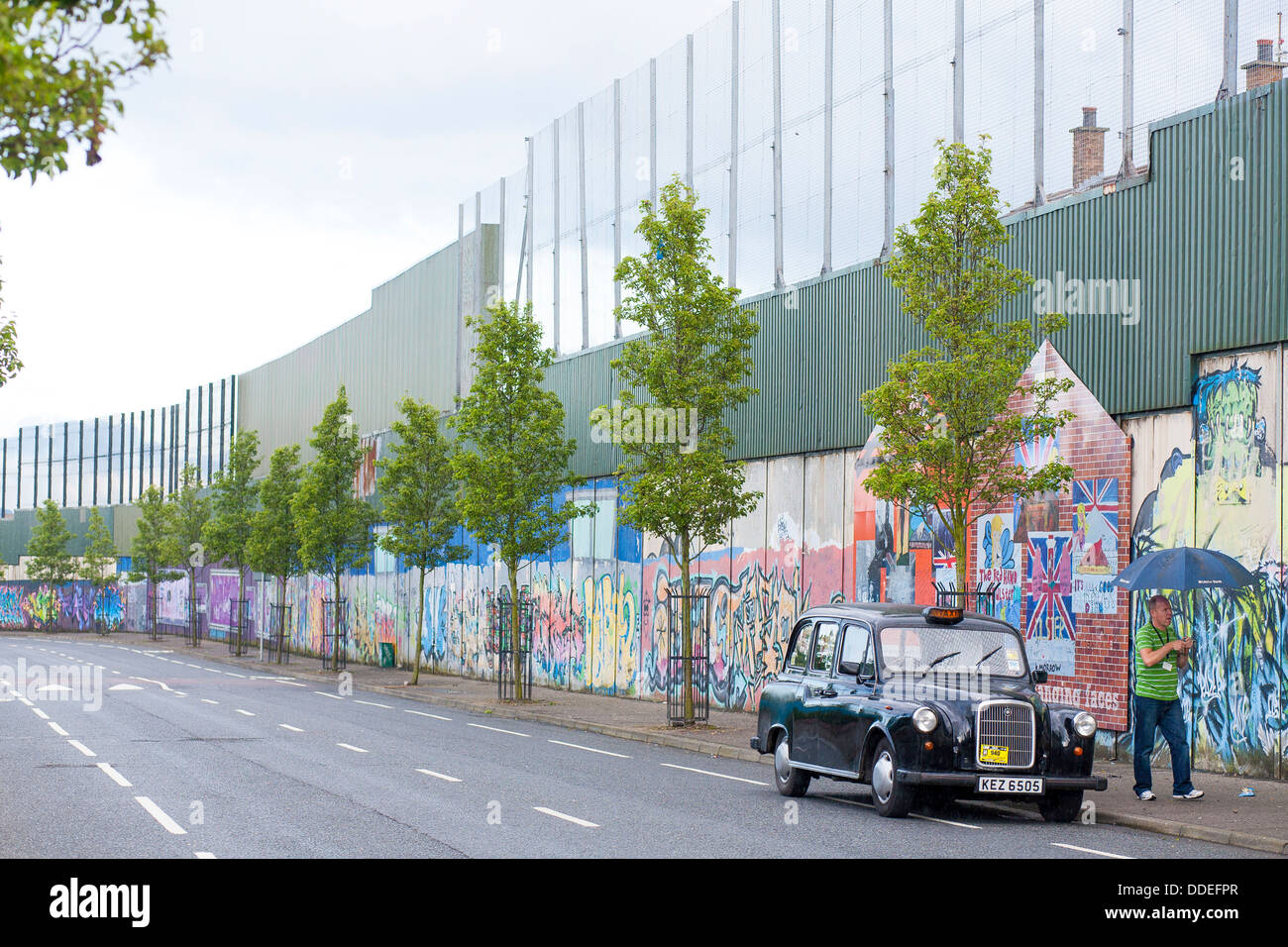 La parete di pace nella parte occidentale di Belfast mantenere i cattolici e i Protestanti da combattimento è coperto in arte per la pace nel nord della isola Foto Stock