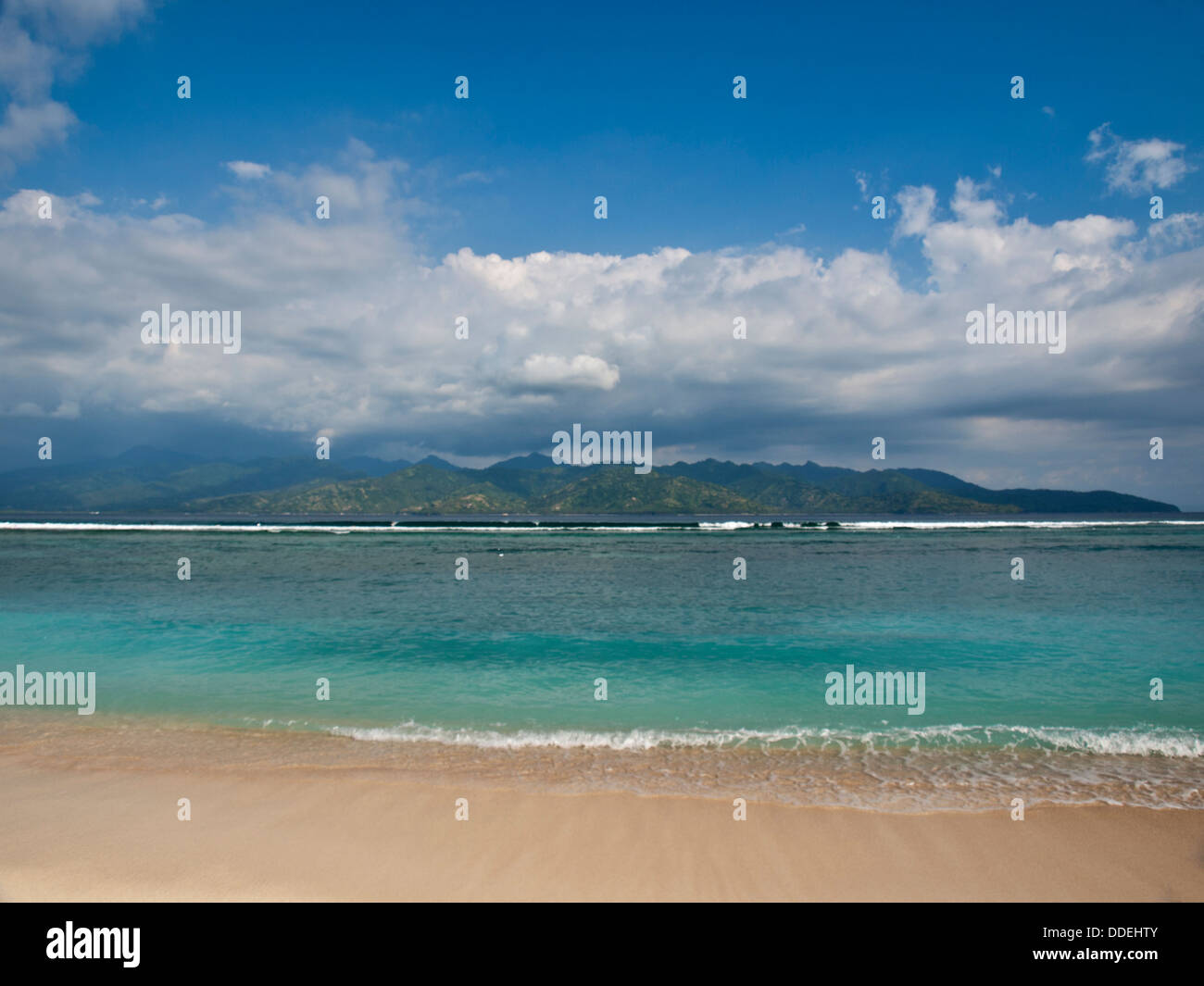 Gili Trawangan mare tropicale con spiaggia dell'Isola di Lombok in background con il bianco delle nuvole sopra Foto Stock