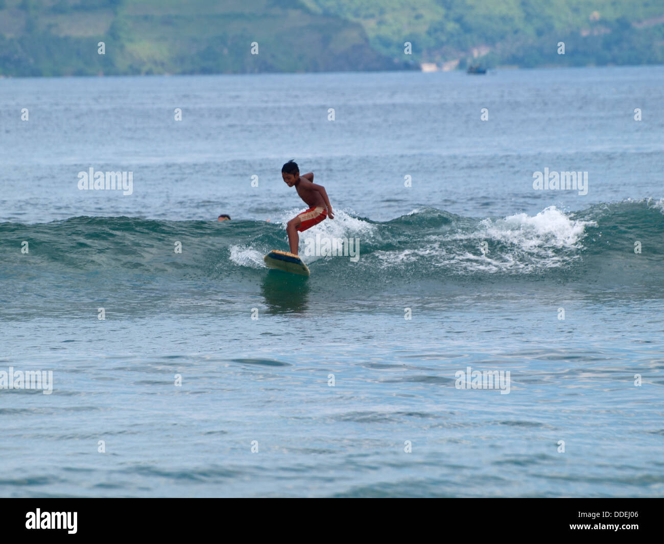 Indonesia n boy surf onde tra Gili Trawangan Lombok e Foto Stock