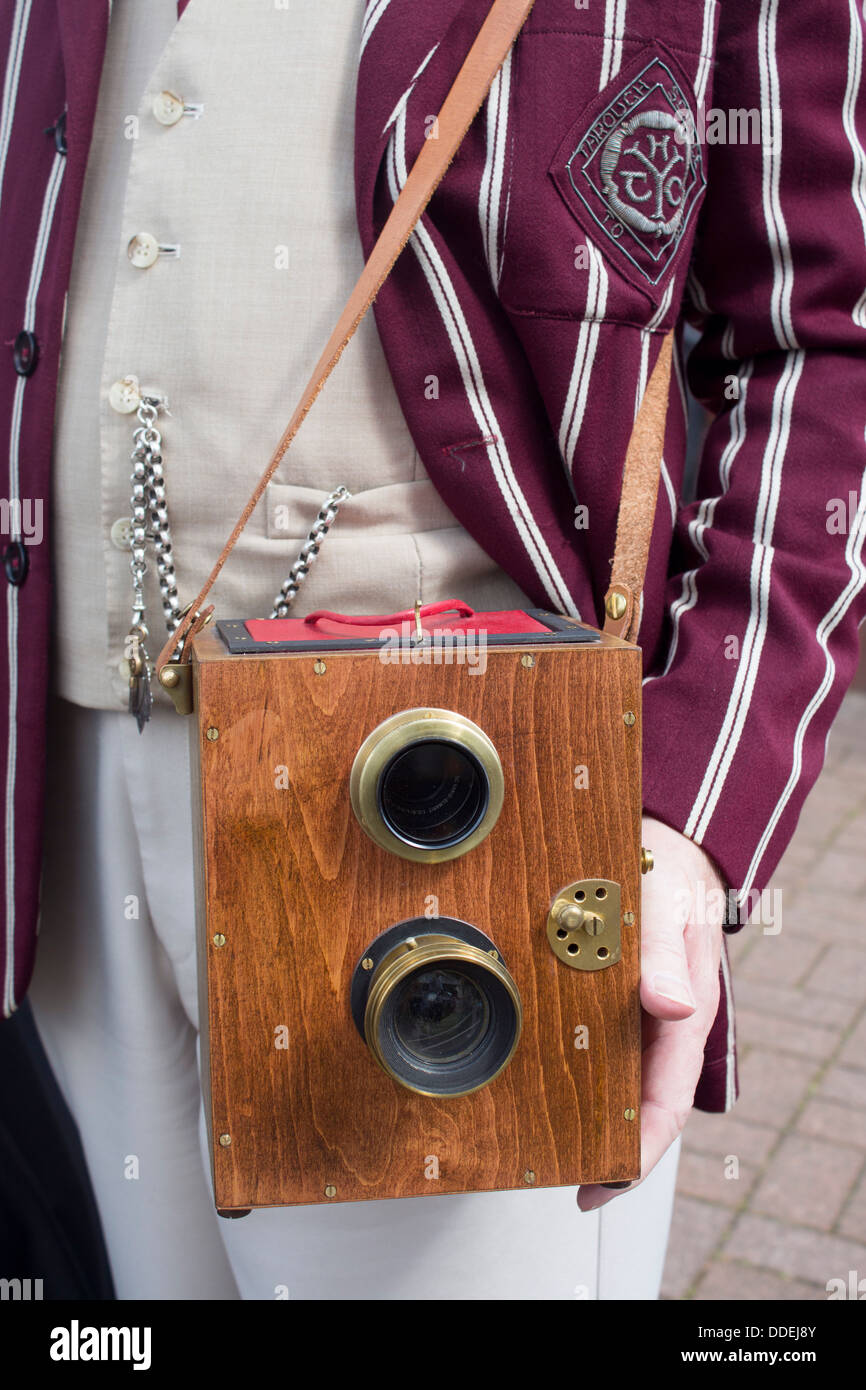Antique classic vintage retrò lente a doppia scatola di legno fotocamera detenute dall uomo nel pin-striped blazer al Festival Vittoriano Wales UK Foto Stock