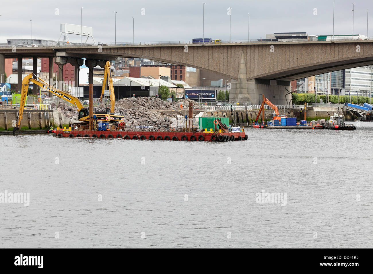 Lavori in corso per riparare la passerella crollata a Anderston Quay sul fiume Clyde utilizzando un digger che lavora da una chiatta a Glasgow, Scozia, Regno Unito Foto Stock