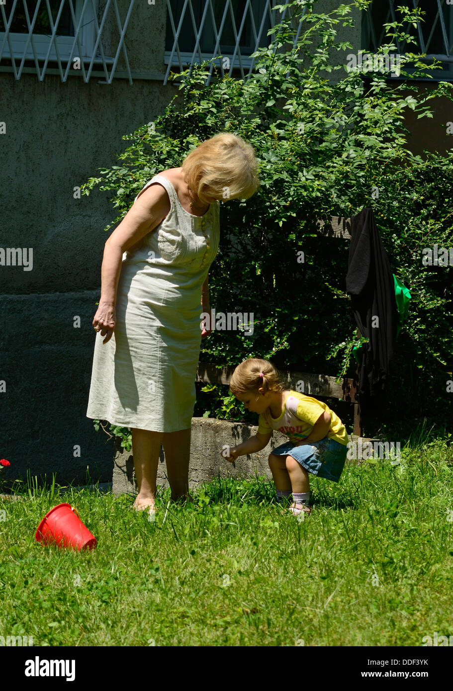 Bambina giocando nel soleggiato parco con la nonna Foto Stock