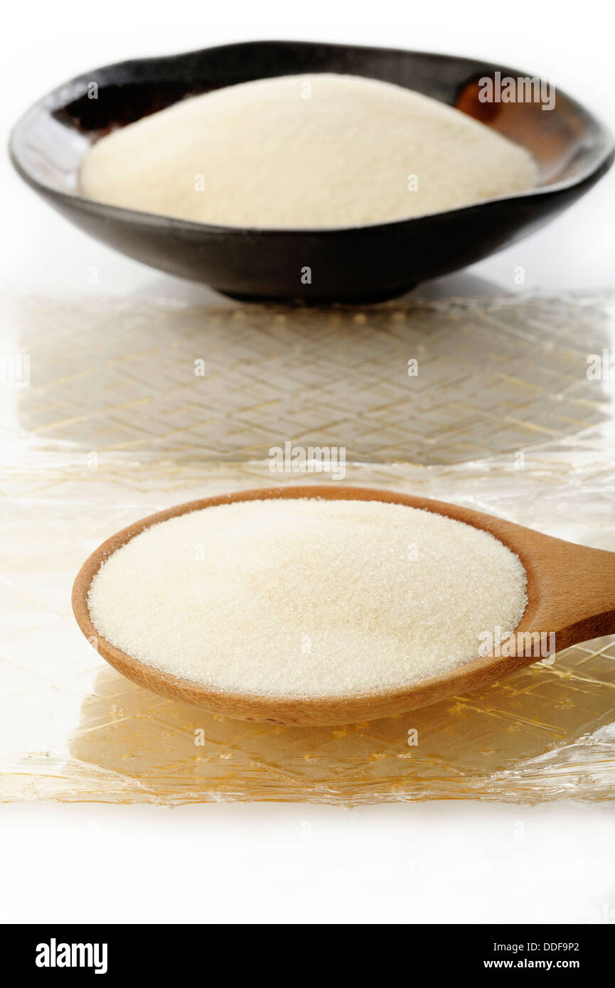 Granuli di gelatina e foglio di gelatina su bianco Foto Stock