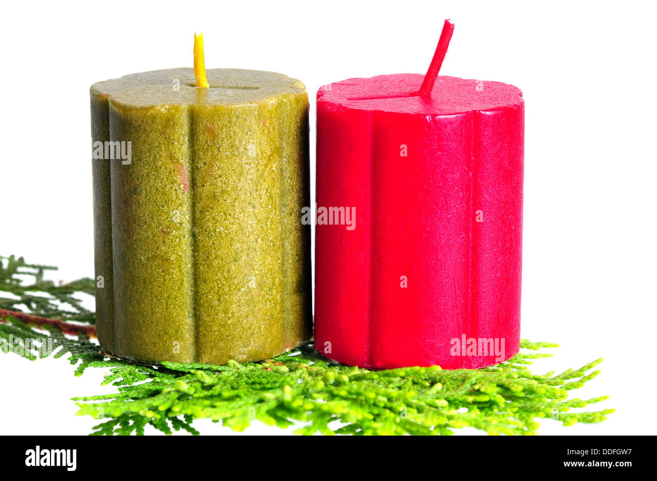 Due candele di natale su una foglia di cipressi su bianco Foto Stock