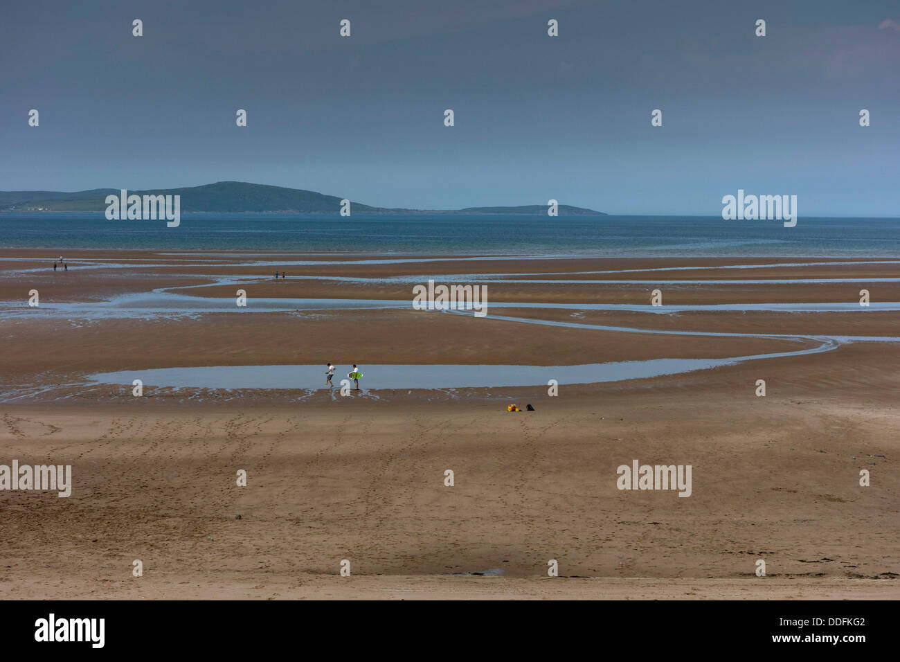 Le figure distanti sulla spiaggia di sabbia con piscine, il blu del mare e del cielo, Gruinard Bay a nord-ovest della Scozia Foto Stock