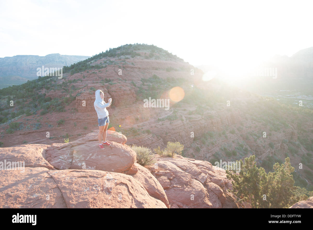 Turistica prendendo foto di sunrise in Sedona in Arizona Foto Stock