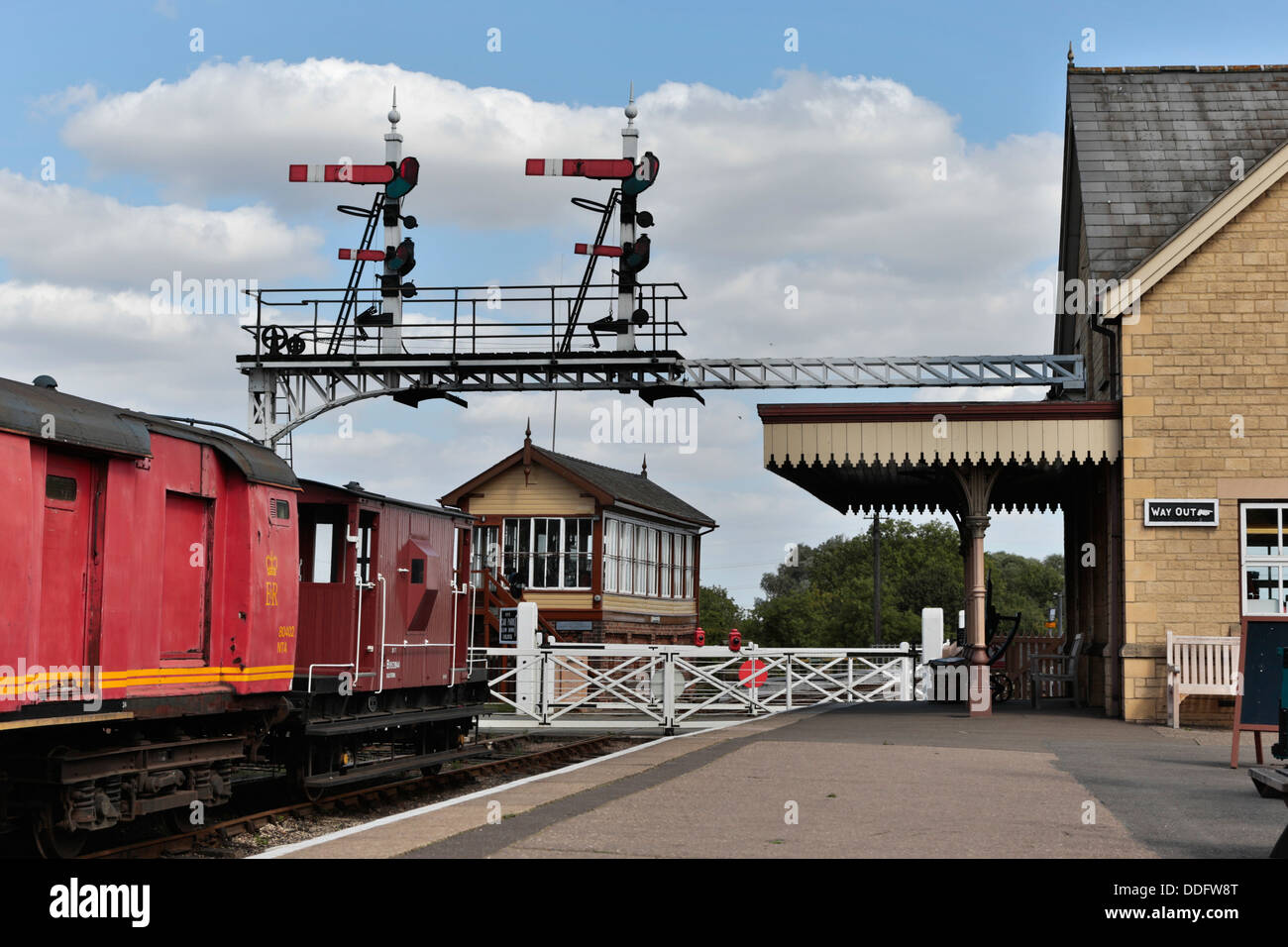 Segnali, carrelli e passaggio a livello Wansford stazione, sul Nene Valley Railway, Cambridgeshire Foto Stock