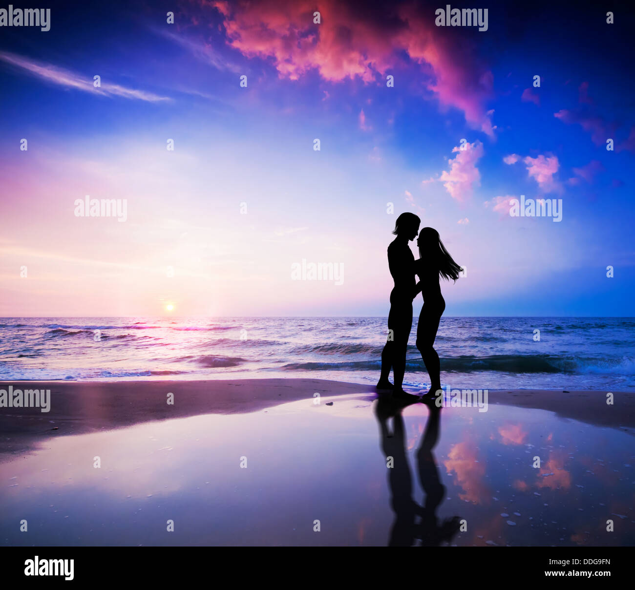 Coppia romantica circa per un bacio sulla spiaggia al tramonto Foto Stock