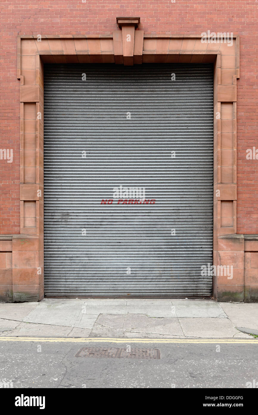 Una porta a rulli con un cartello No Parking, Glasgow, Scozia, UK Foto Stock