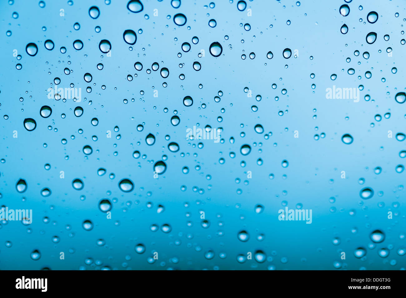 Sfondo di gocce di acqua sul vetro di colore blu Foto Stock
