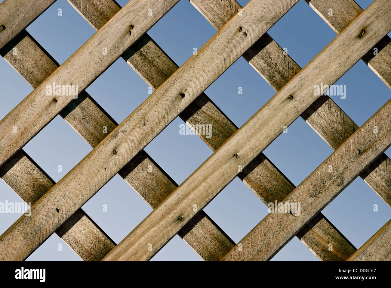 Un primo piano di un traliccio in legno recinto con cielo blu Foto Stock