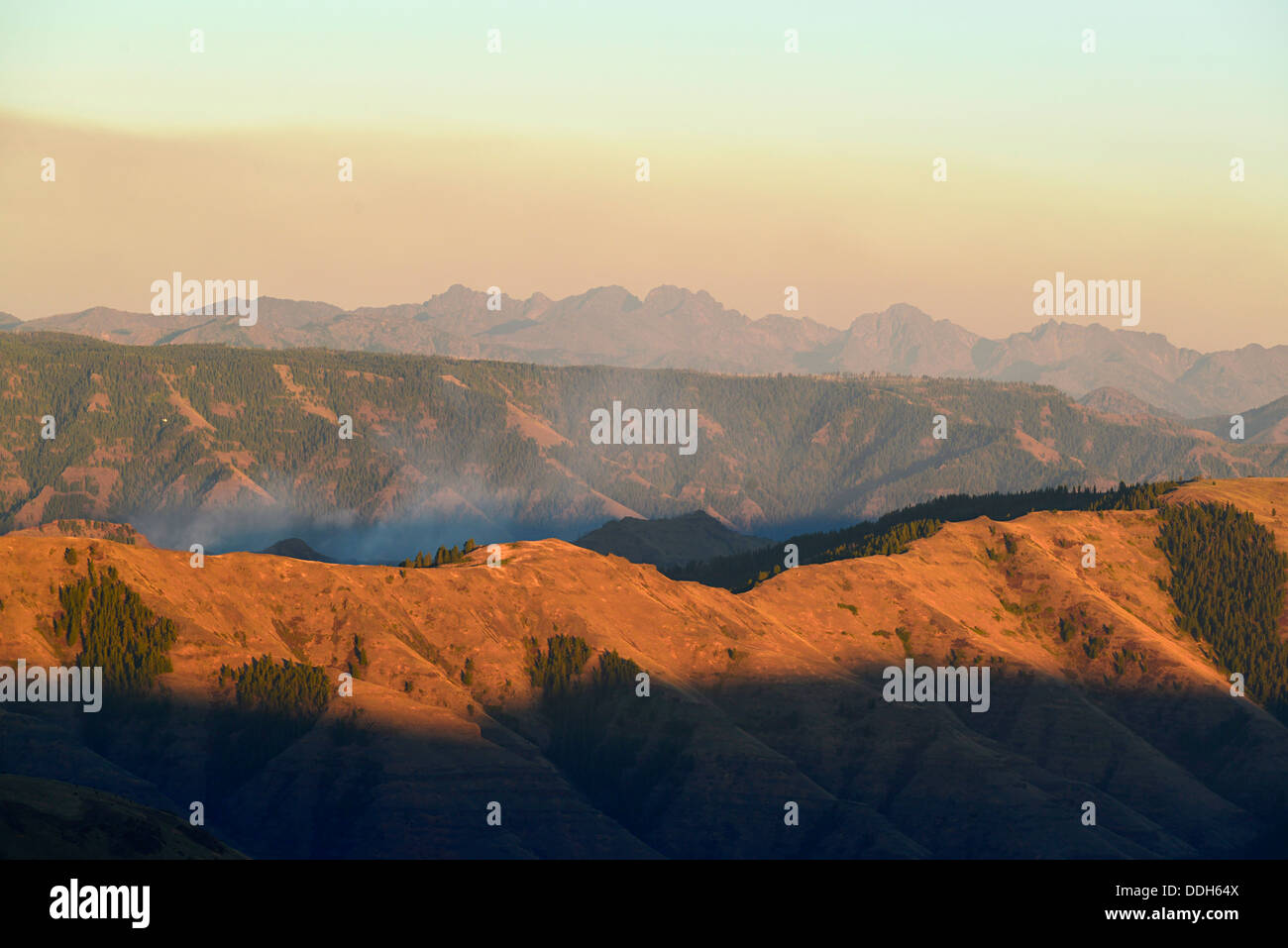 Fumo da un incendio di foresta in Hells Canyon, Oregon. Il Diavolo Sette Montagne di Idaho sono in background. Foto Stock
