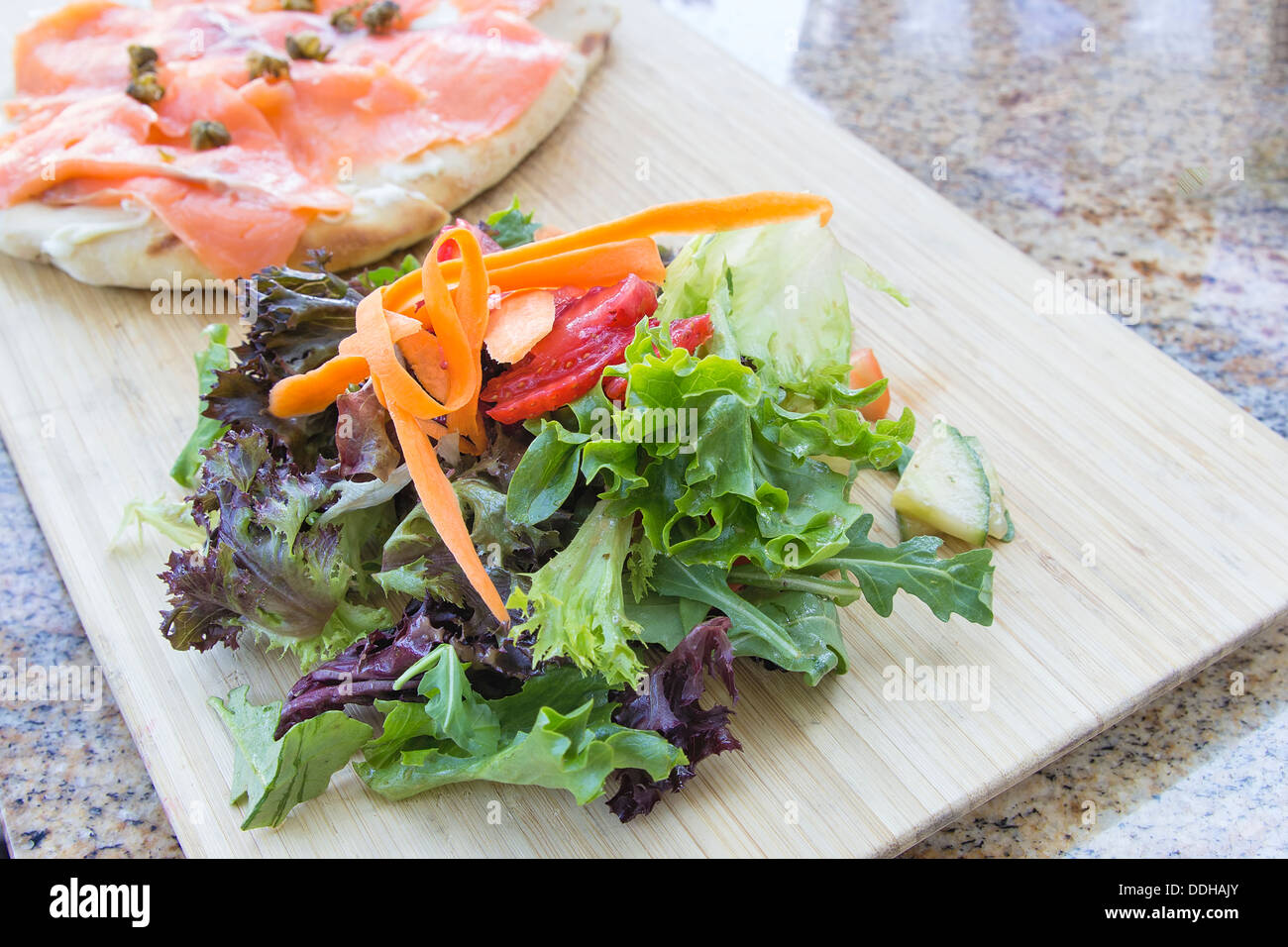 Organici di insalata di verdure verdi con la carota fragola e salmone affumicato su pane focaccia Closeup Foto Stock