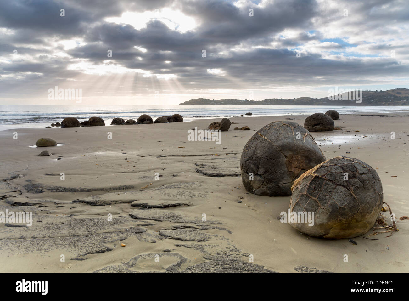 Moeraki Boulders sulla spiaggia con raggi di sole al mattino presto Foto Stock