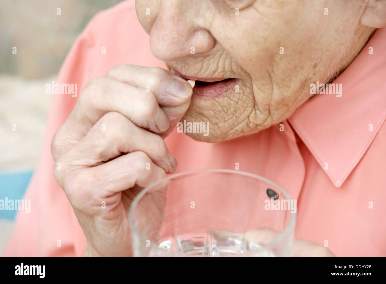 Donna anziana di prendere una compressa di simvastatina (statine) Farmaci che riduce la quantità di colesterolo e di trigliceridi nel corpo Foto Stock