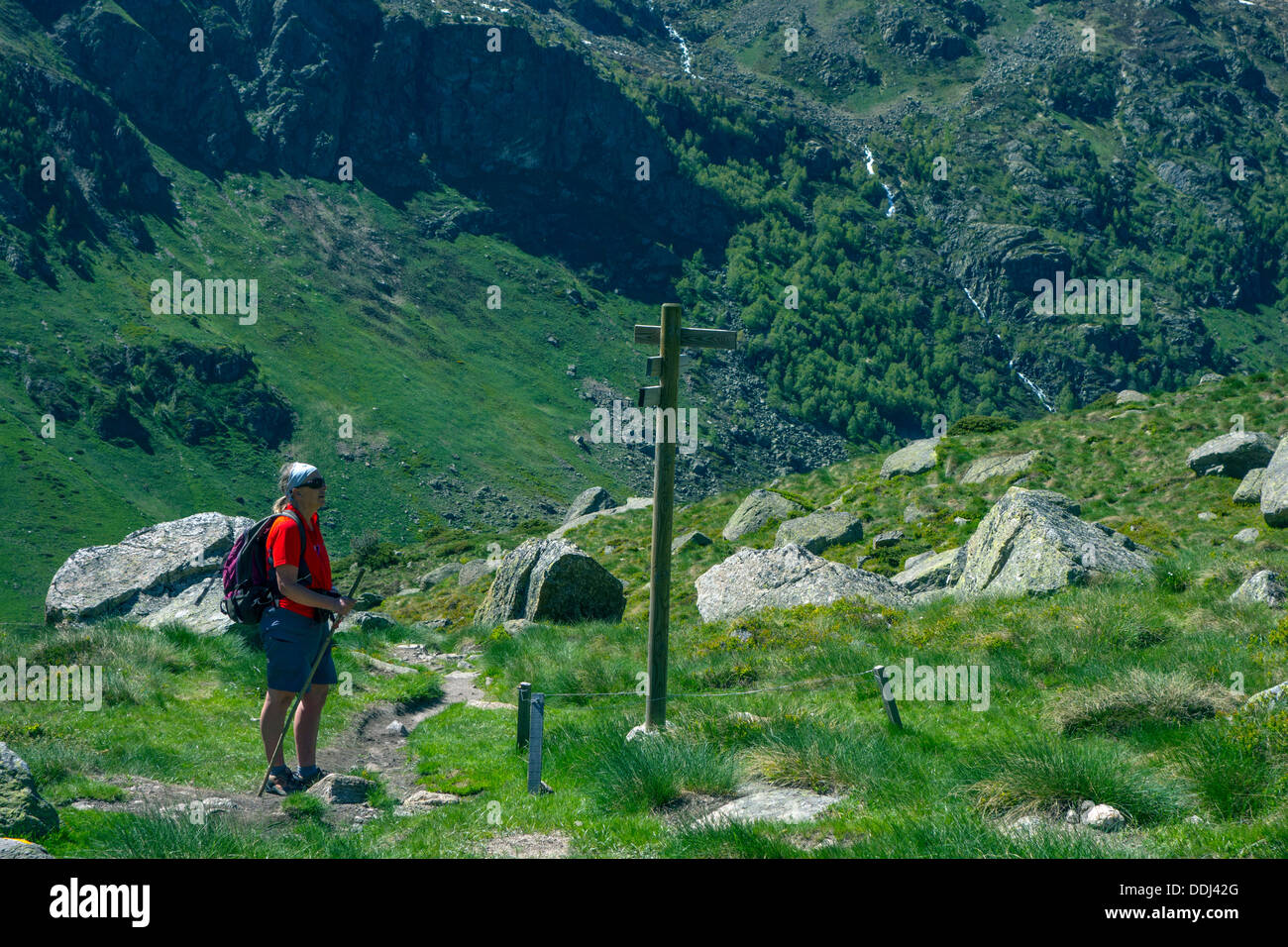 Figura femminile in rosso walking escursioni nei Pirenei francesi con segnaletica Foto Stock