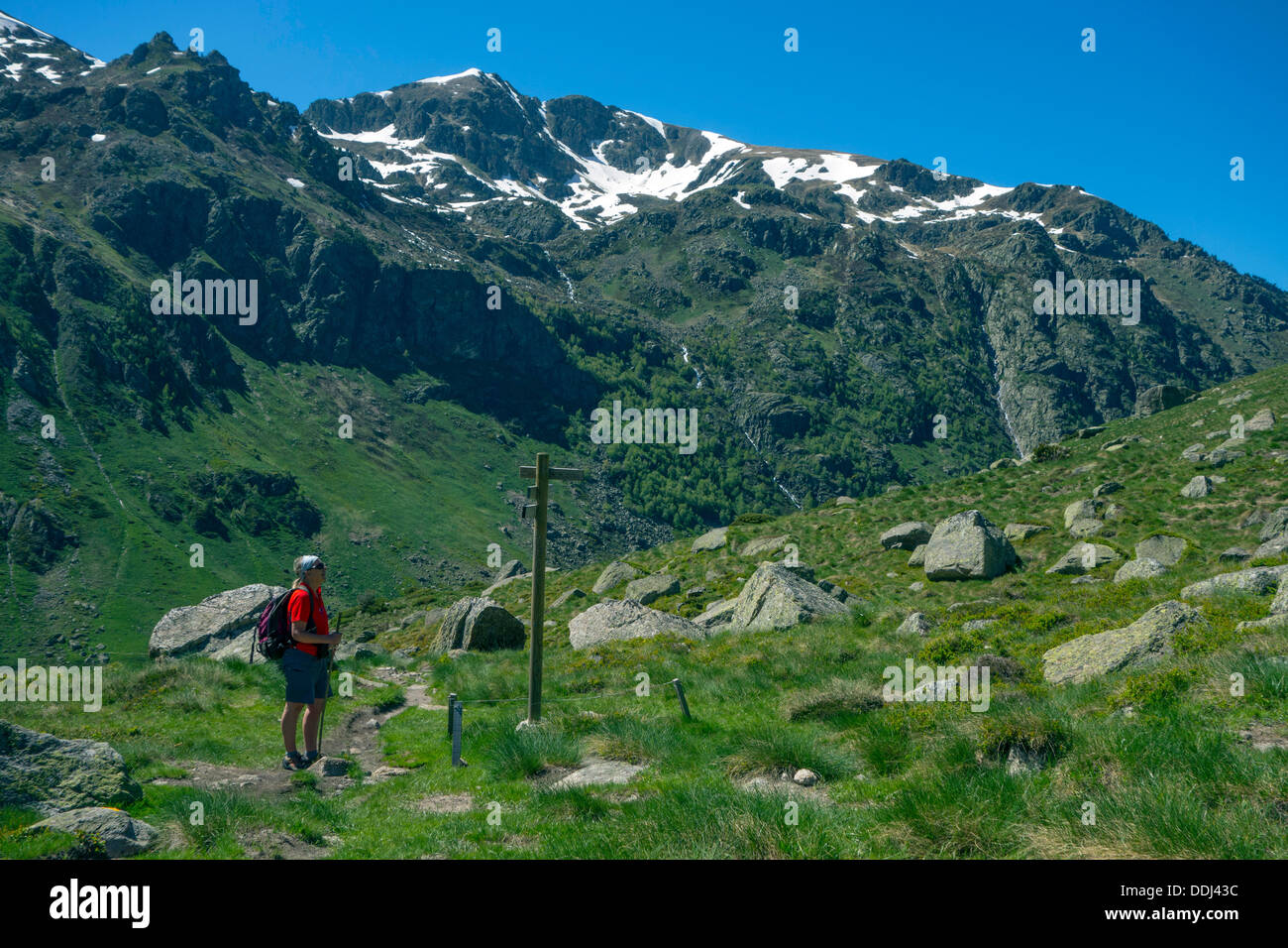 Figura femminile in rosso walking escursioni nei Pirenei francesi con segnaletica Foto Stock