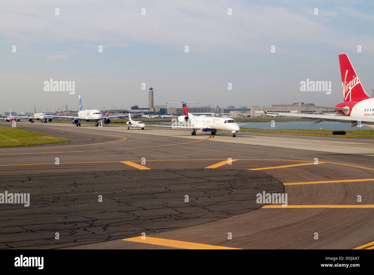 L'Aeroporto Logan di Boston pista con aeroplani allineati pronti per il decollo Foto Stock