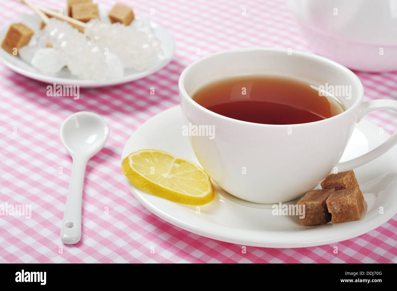 Tazza di tè con limone e rosa su sfondo a scacchi Foto Stock