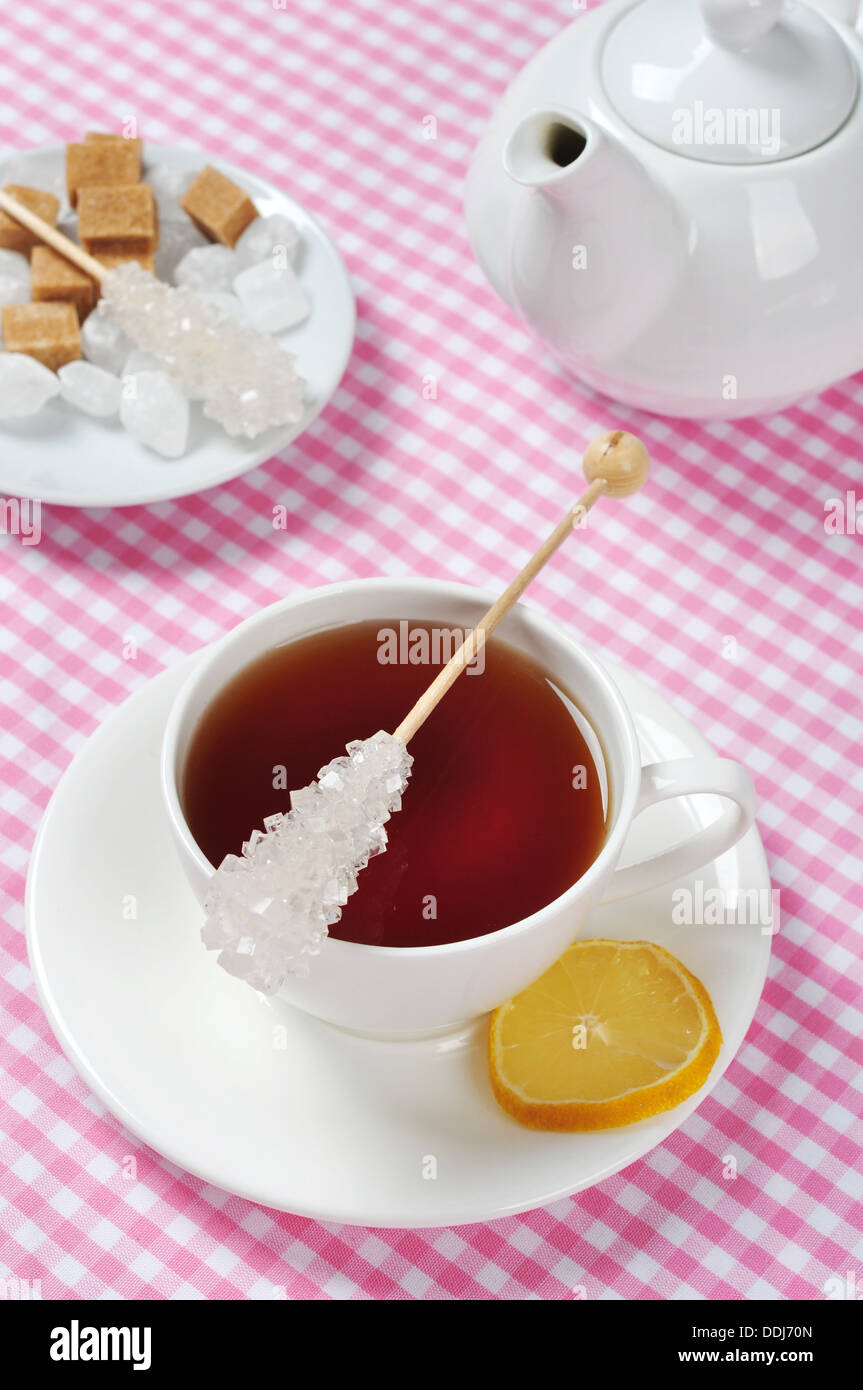 Tazza di tè con limone e rosa su sfondo a scacchi Foto Stock