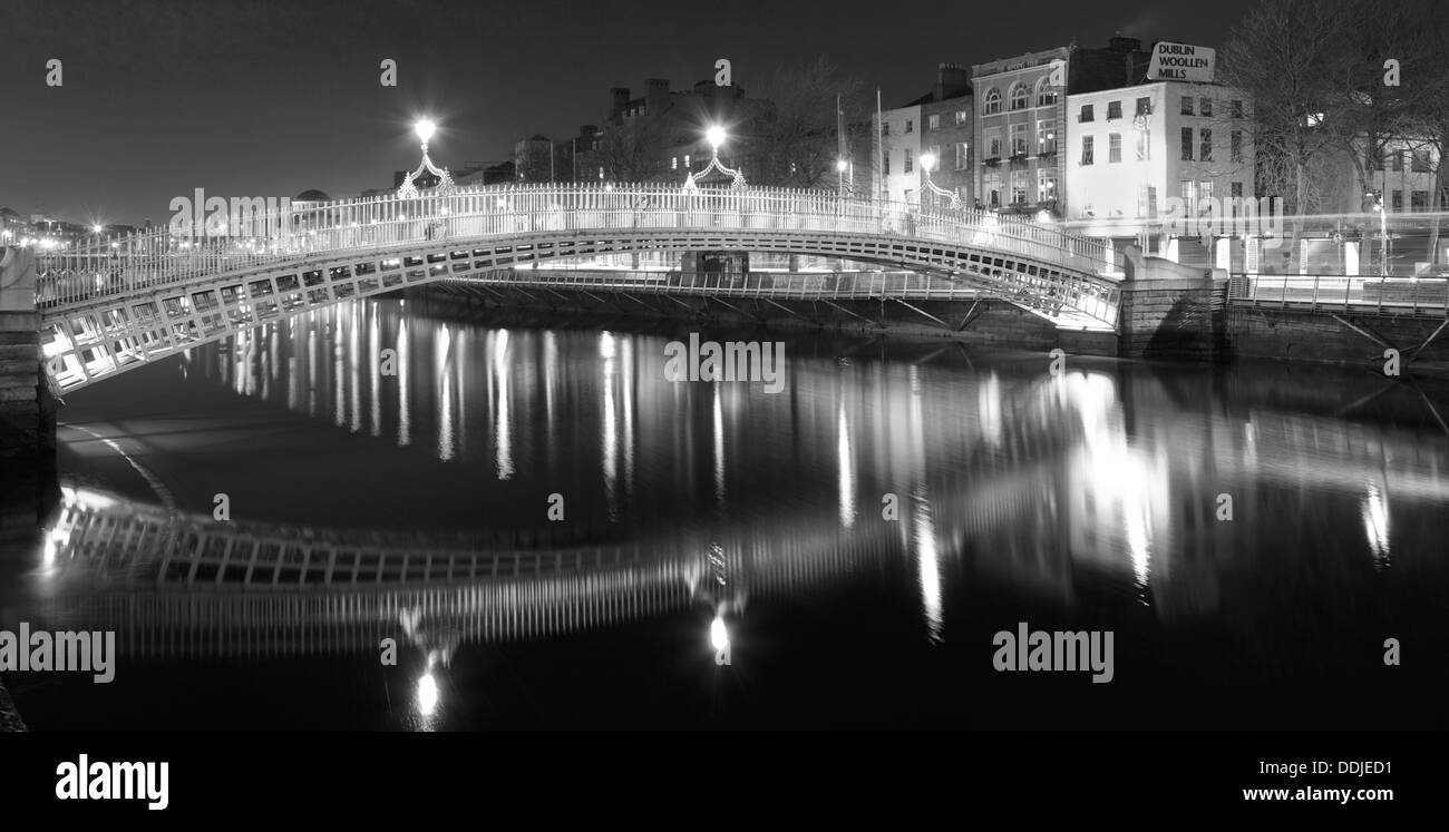 L'Ha'penny Bridge Dublino Irlanda durante la notte in bianco e nero con riflessi Foto Stock