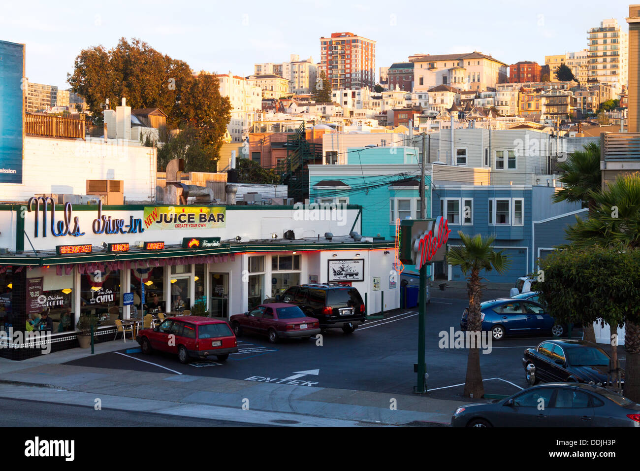 Vista del centro storico di Mel's drive in ristorante nelle ombre del tardo pomeriggio di sole edifici di illuminazione sul pendio di una collina dietro. Foto Stock