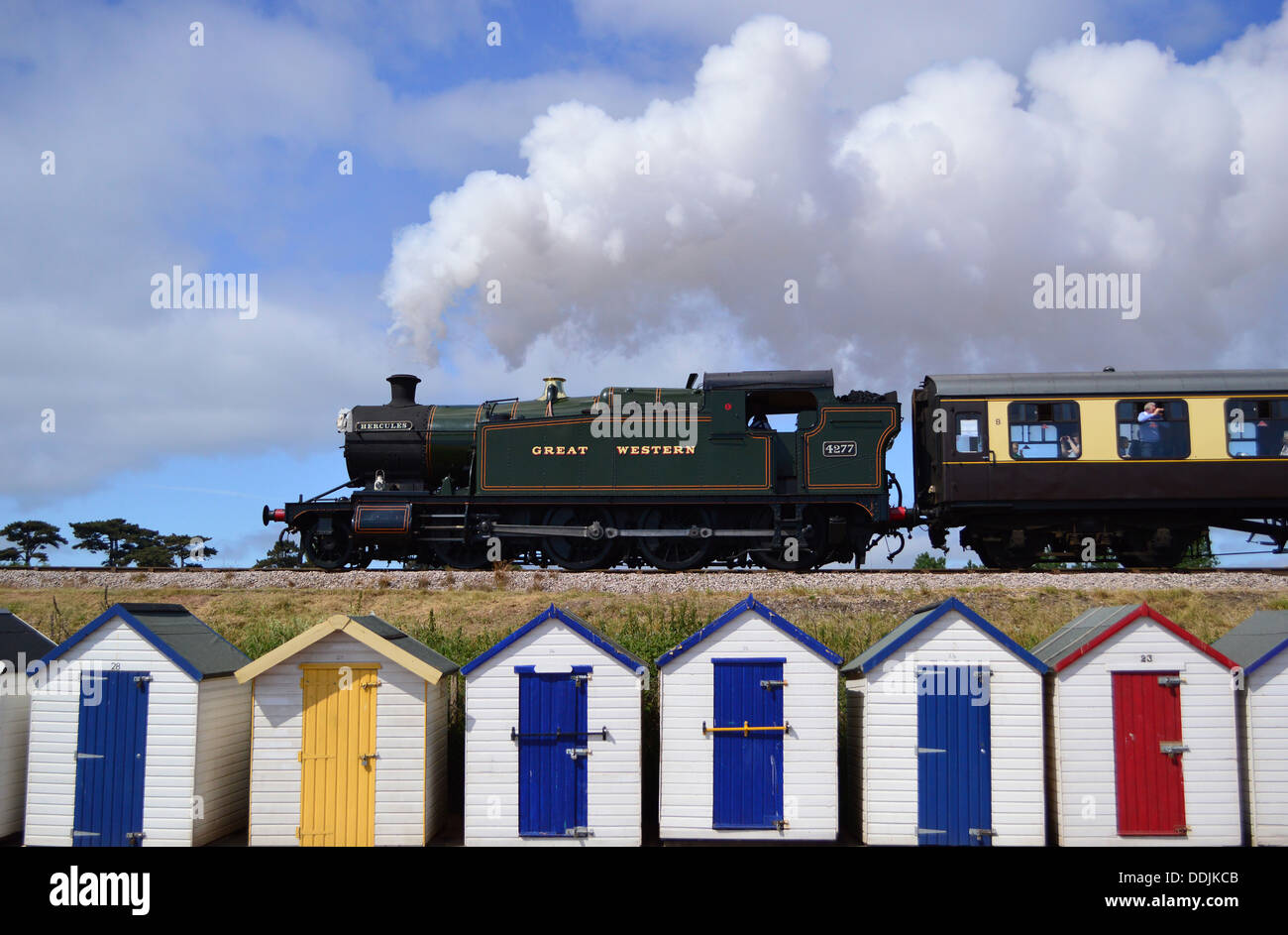 Treno a vapore sopra pittoresca spiaggia di capanne a Goodrington, Torbay, South Devon, in Inghilterra, Regno Unito Foto Stock