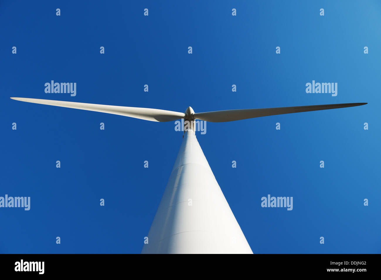 Una turbina eolica presa dal basso contro il cielo blu Foto Stock