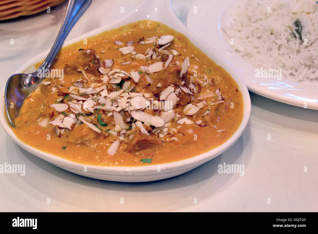 Oriente il cibo indiano di agnello Korma Curry con mandorle e riso Basmati Closeup Foto Stock
