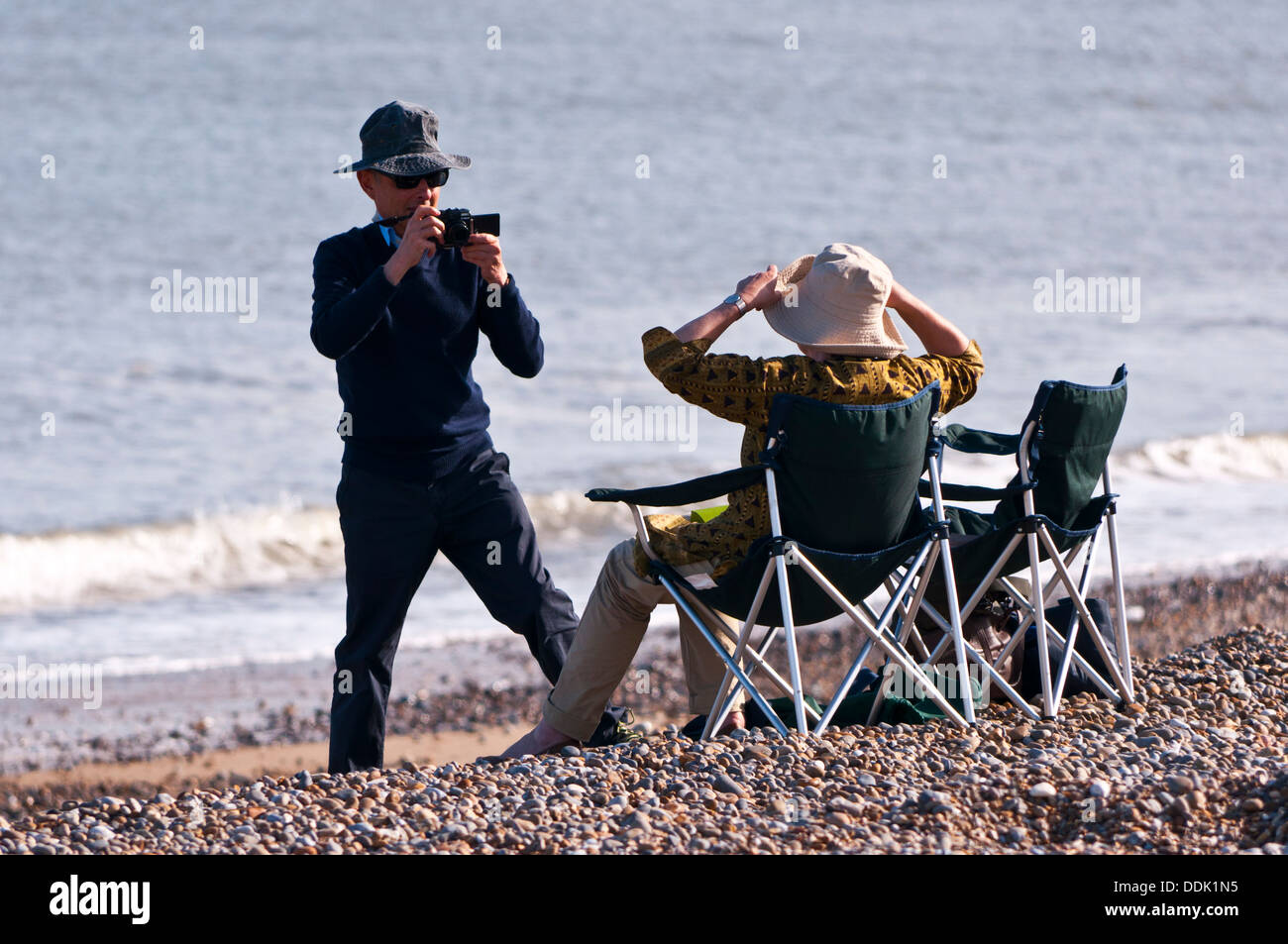 Titolare di pensione o di rendita giovane sulla spiaggia prendendo fotografia Foto Stock