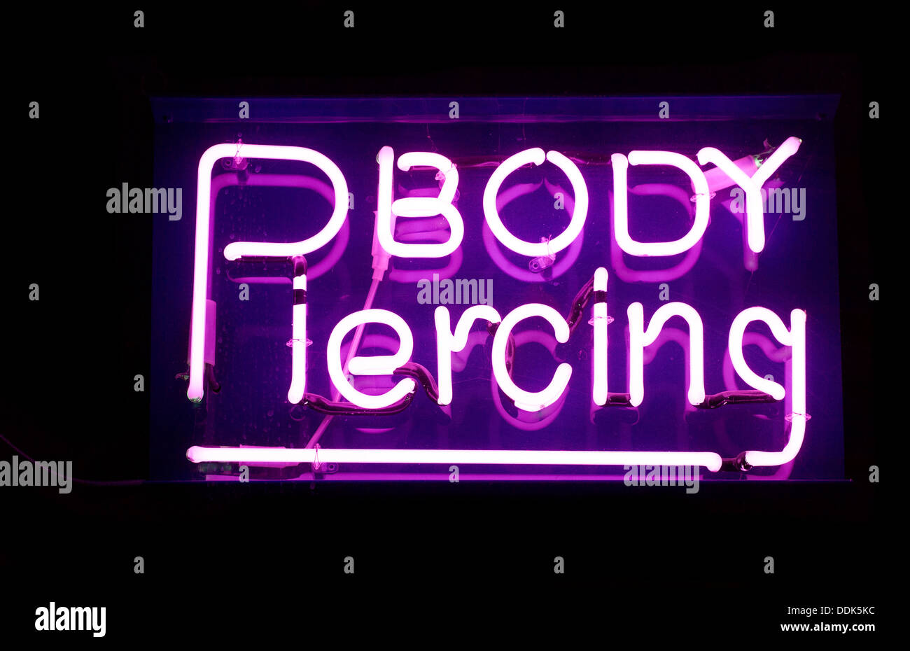 Il Neon viola body piercing segno studio ritaglio Foto Stock
