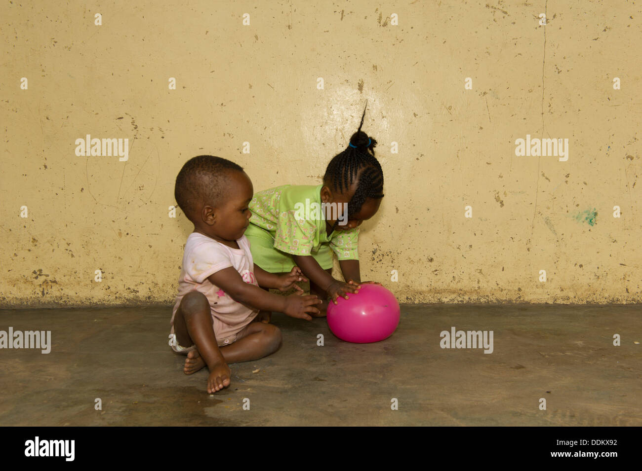 I bimbi di posti a sedere su un pavimento di calcestruzzo in Nigeria Foto Stock