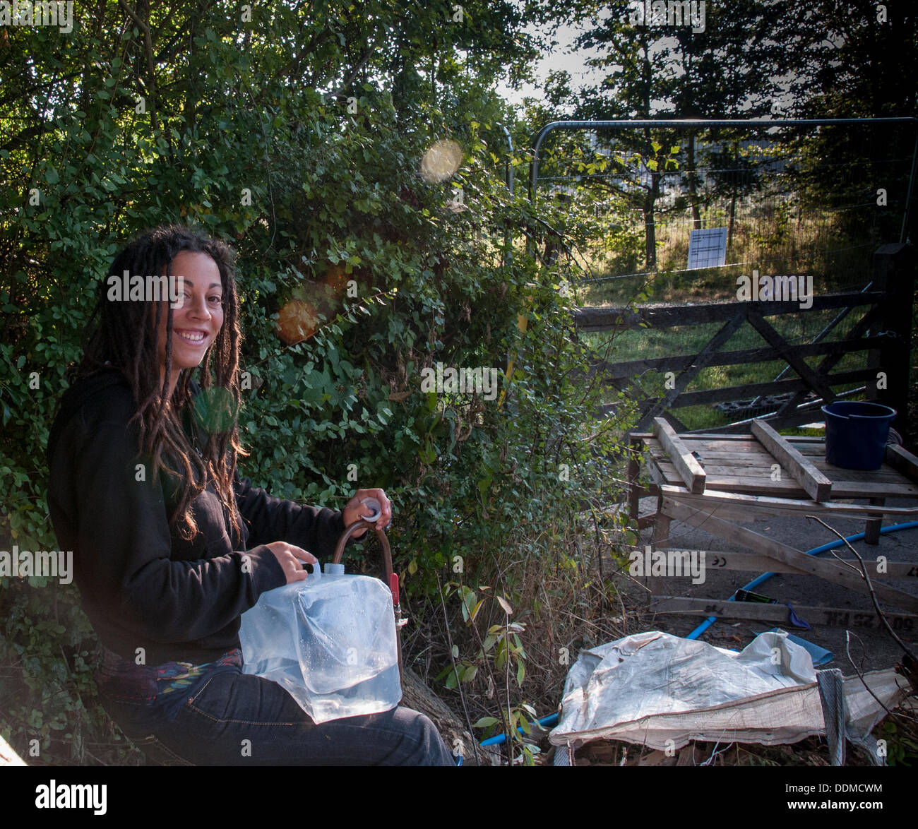 Balcombe, West Sussex, Regno Unito. Il 4 settembre 2013. Piuttosto ambientalista Maria riempie contenitori di acqua sul ciglio della strada al di fuori del sito Cuadrilla recinto. Il anti fracking ambientalisti stanno protestando contro forature di prova da Cuadrilla sul sito in West Sussex che potrebbe portare al controverso processo fracking. Credito: David Burr/Alamy Live News Foto Stock