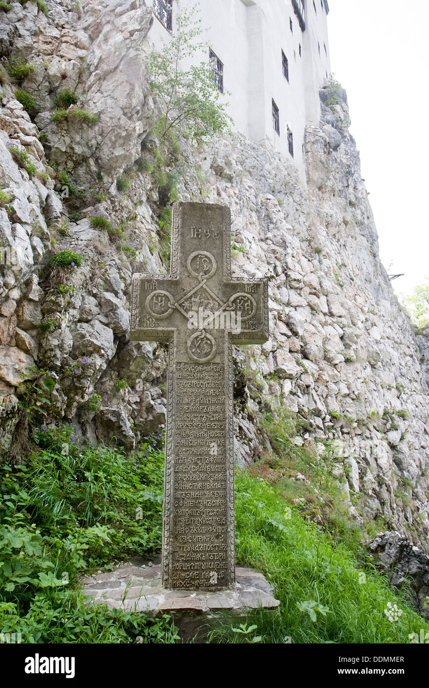 Antica croce di pietra vicino alla parete della Crusca castello medievale, Valacchia, Romania Foto Stock