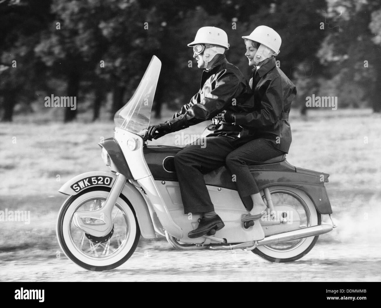 Un uomo e una donna a cavallo di un Ariel Leader, 1958. Artista: sconosciuto Foto Stock