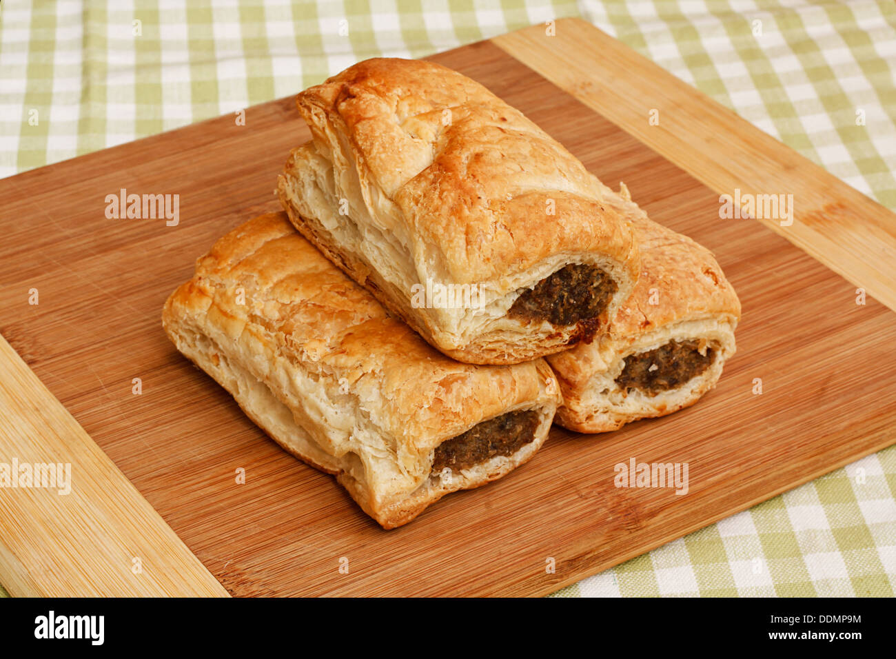 Tre salsiccia tradizionale rotoli su un rustico cafe impostazione tabella, una rinomata pasticceria snack disponibili dal british fornai Foto Stock