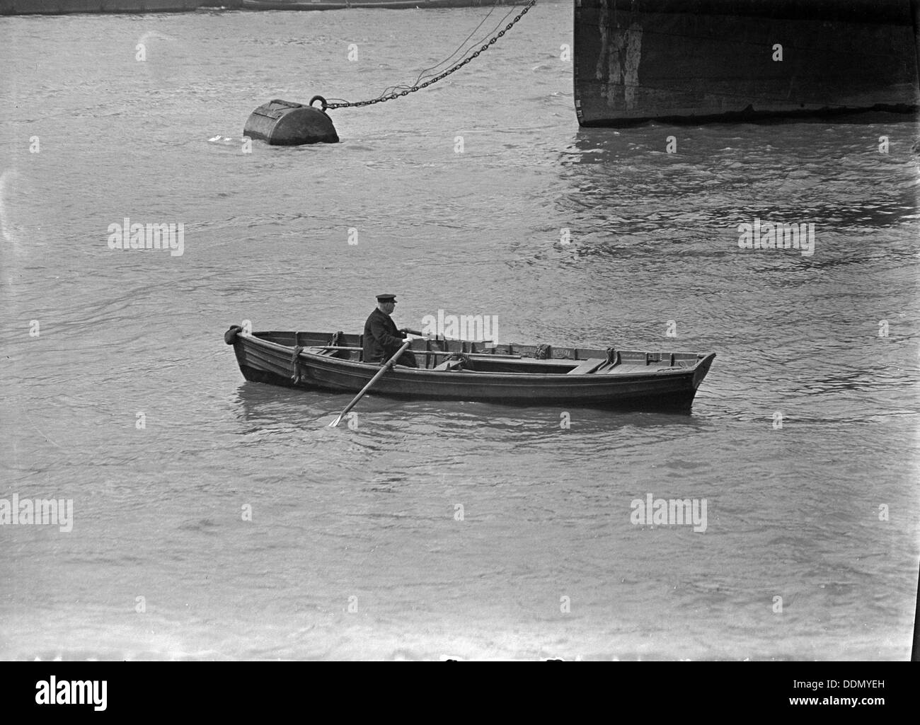 Un uomo che rema con una barca in docks londinesi, C1945-c1965. Artista: SW Rawlings Foto Stock