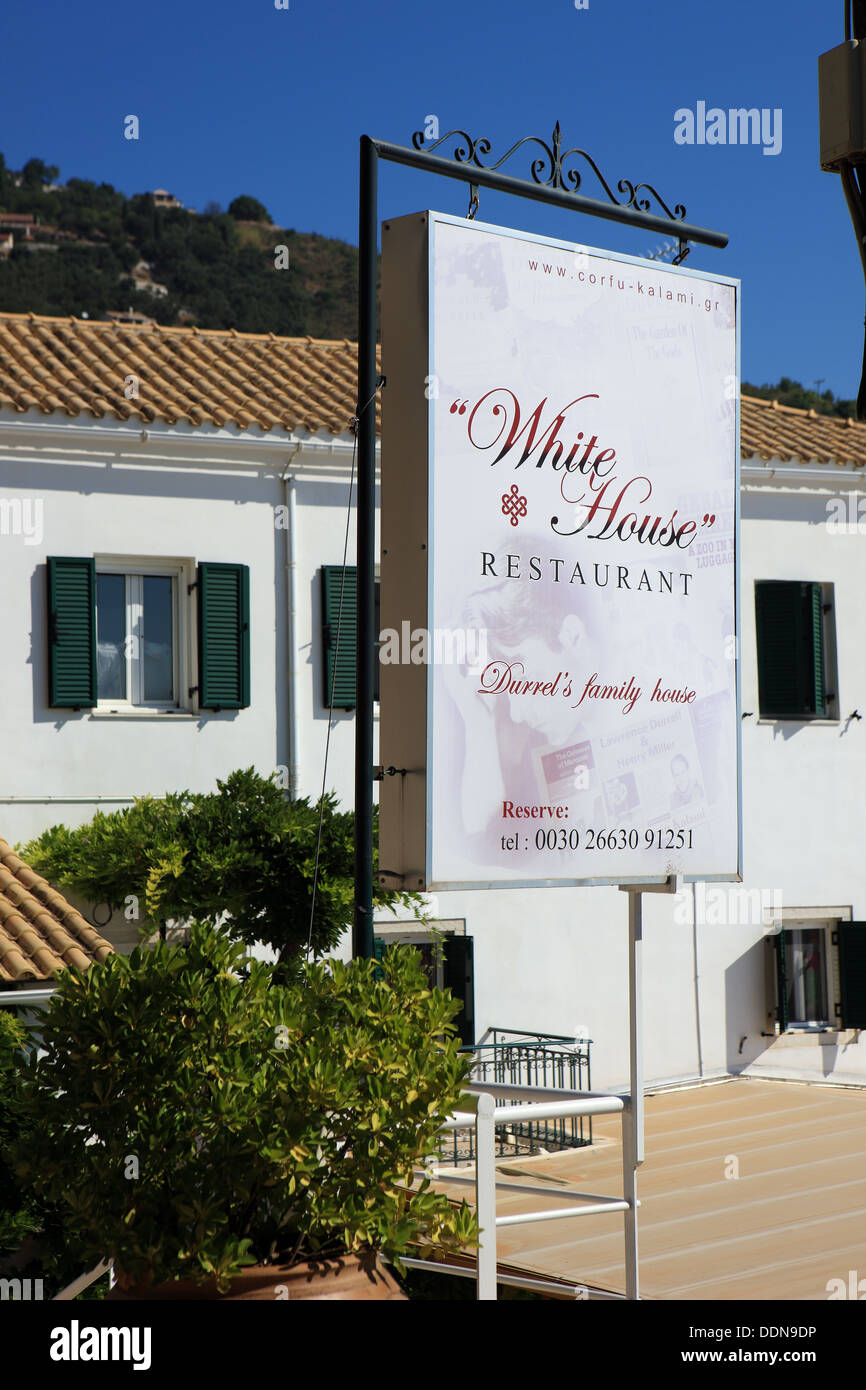 La Casa Bianca ristorante dietro il segno in Kalami Corfu. In precedenza la casa greca di autori Gerald e Lawrence Durrell. Foto Stock