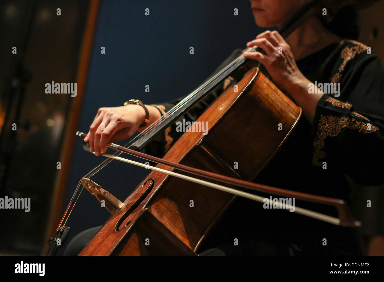Close up violoncellista con le mani in mano e la prua mentre suona un violoncello Foto Stock