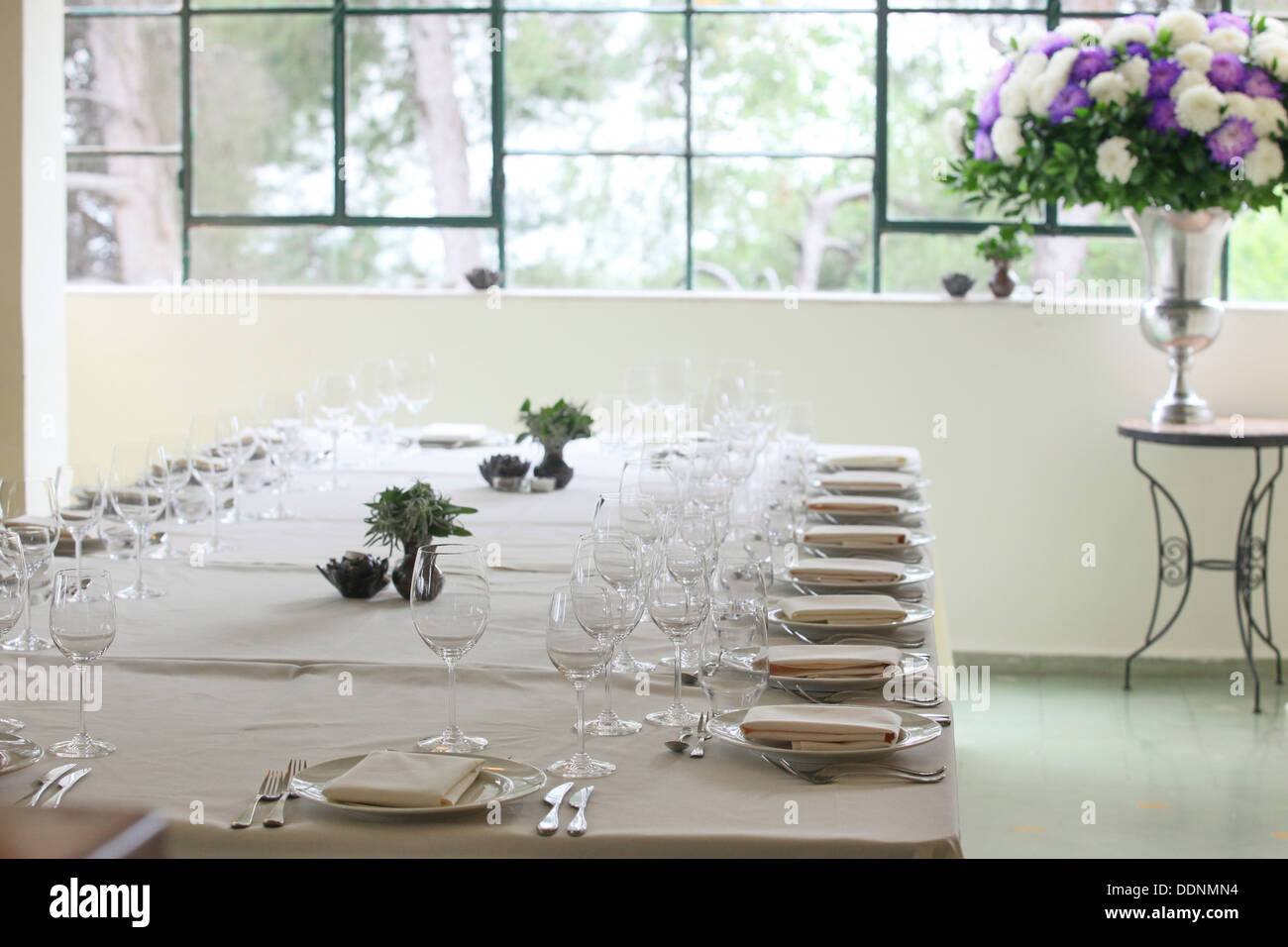 Festosa messa in tavola con bianche tovaglie e fiori Foto Stock